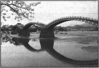 , , ,  Kintai Bridge is a wooden bridge and one of three most famous bridges in Japan. Its five-arch structure is beautiful. The structure was completed by Kikkawa Yoshihiro of the Iwakuni Domain in 1673. The bridge was destroyed by a typhoon and ﬂooding in 1950, but was rebuilt in 1953. The length of the bridge is 193.3 meters across (210 meters long along the bridge surfce). It is 5 meters wide and is 6.64 meters high.,  Kintai Bridge can be crossed from the town-side or mountain-side. Cherry blossom season here is a must-see and the bridge is always crowded with visitors. The Kintai Bridge Festival is held on April 29 and visitors can see a traditional Japanese parade. During the summer months, visitors can also watch Ayu fishing by cormorants at night. In August, there is a firework festival along the river, which features 6000 fireworks.,  The Kintai Bridge can be crossed at any time of the day. However, when there is no one at the toll booth, visitors are to pay 300 yen per adult and/or 150 per child into the fare box. The bridge is illuminated at night and a night visit is also recommended., " On the mountain-side, there are various restaurants and gift shops. Visitors can enjoy lwakunis specialty, Iwakuni sushi. It is famous for its vivid visual presentation using rice, vegetables, egg and fish. There is even a store which sells 100 kinds of soft-serve ice cream. Also on the mountain-side are Iwakuni Castle and lwakuni Museum of Art. The lwakuni Museum of Art has a substantial exhibition of samurai armors and swords."
